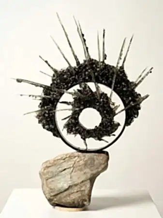 TUNCAY KOÇAY tarafından 2026 yılında 32x44x12 cm ölçülerinde Polyester reçine, torna talaşı, metal, doğal taş tekniği ile yapılmıştır.